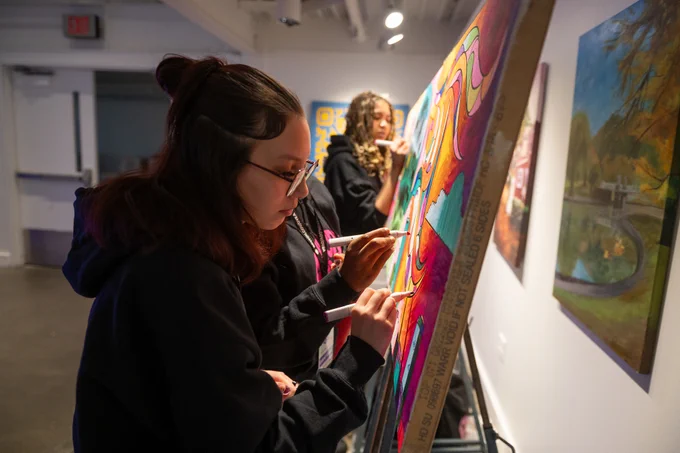 young adults painting a mural at a City event