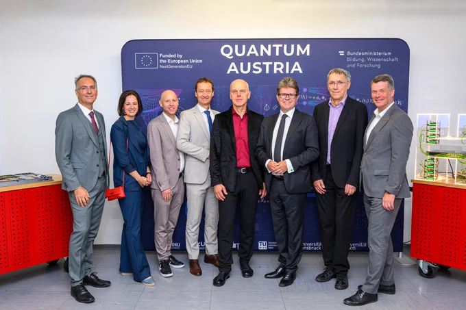 Eine Gruppe von Menschen steht vor einem Schild.