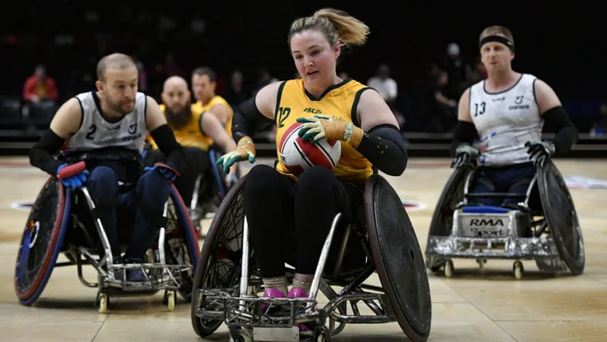 5 people on a court playing wheelchair rugby