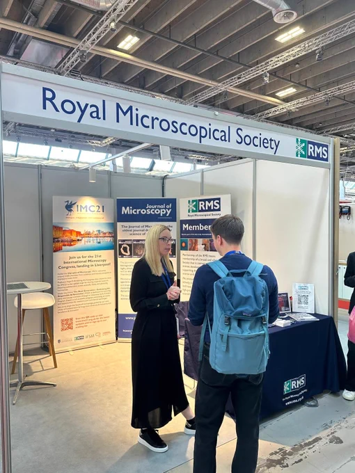 An attendee at emc2024 chats to a member of RMS staff at the RMS exhibition stand.