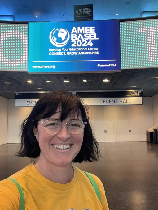 Clare standing in front of the AMEE 2024 entry sign