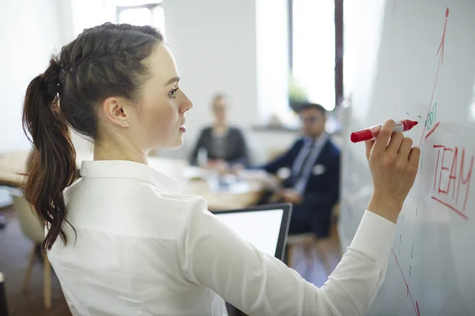 Woman writing on a white board