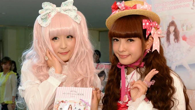 Two people dressing in ultra-feminine style smiling to camera