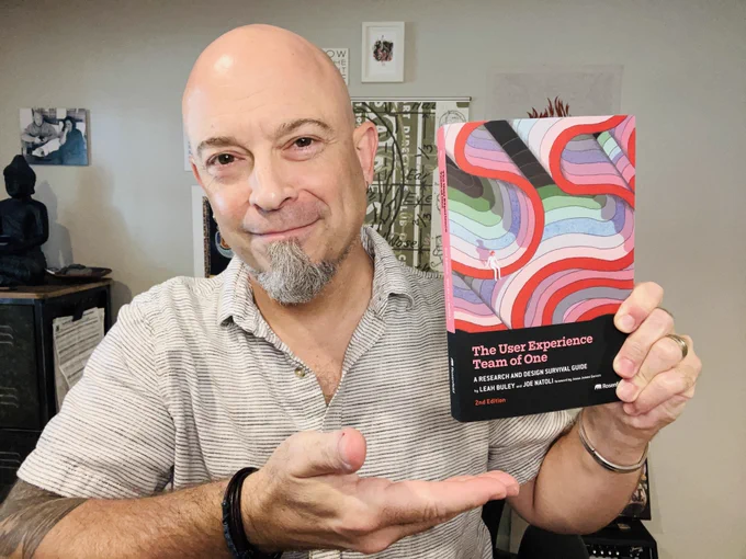 Author Joe Natoli holding a hard copy of his most recent book, co-authored with Leah Buley, the second edition of "The User Experience Team of One."