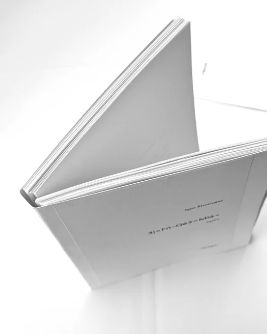 A printed draft of a white book with black letters on a white table.: Igor Štromajer 3¦×Fń–Qé3=Miá  -oµ4×