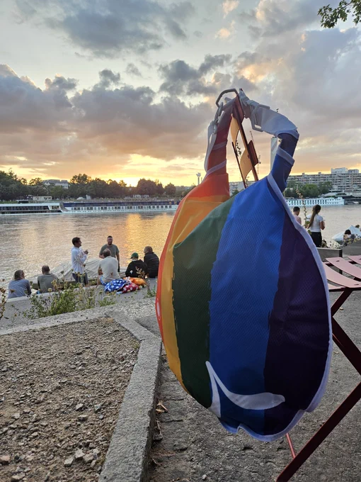 wickelfisch in rainbow colours slung over chair post swim as sun sets in background 
