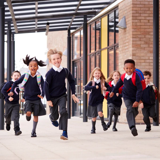 A group of school children running outside school