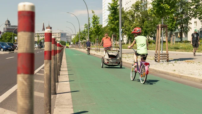 Ein Kind fährt mit dem Fahrrad auf einem geschützen Radweg.