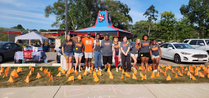 WAVE's 2024 Youth Summer interns stand together in front of flags representing lives taken by gun violence