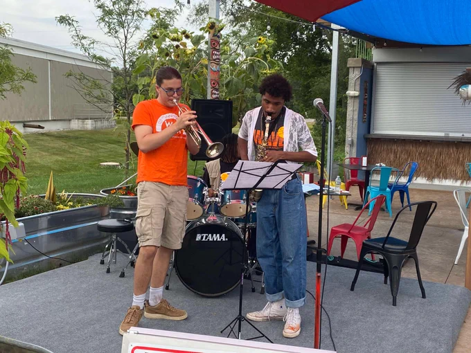 two teenagers play a trumpet and a saxophone