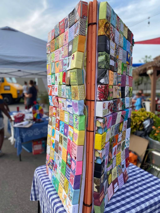 Image shows a panel of boxes folded from paper. Each box represents one life that has been taken by gun violence.