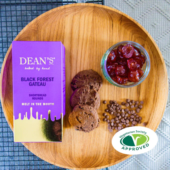 Purple box of Dean's Black Forest Gateau Shortbread Rounds on a wooden tray.