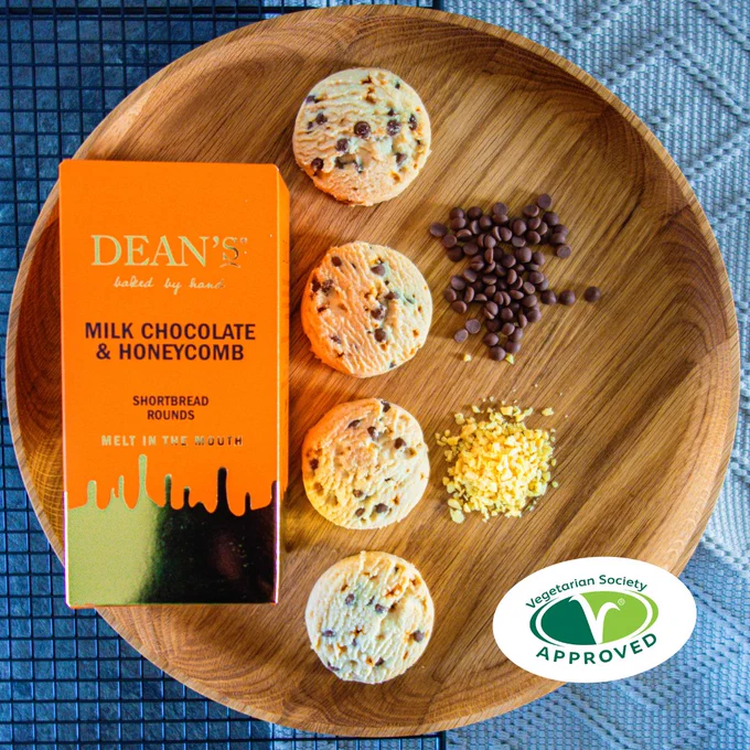 Orange box of Dean's Milk Chocolate and Honeycomb Shortbread Rounds on a wooden tray.