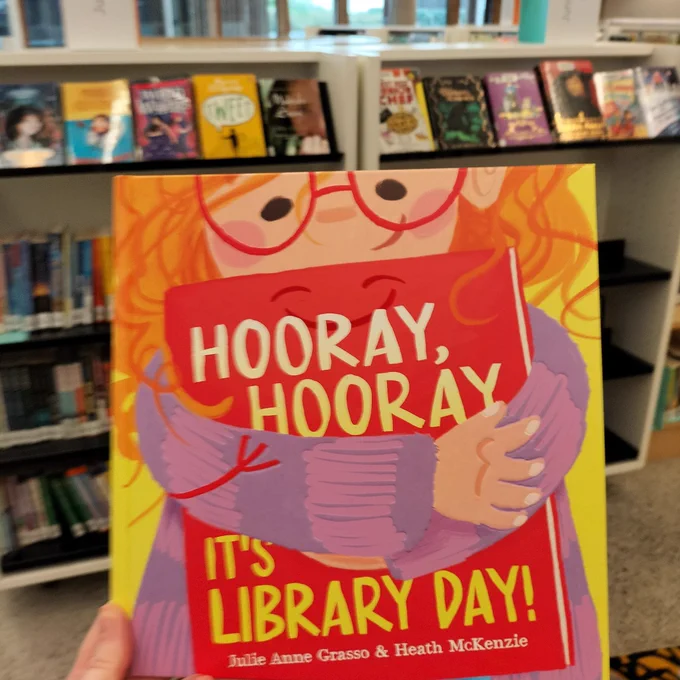 Cover of Hooray, Hooray, It’s Library Day! Cover shows a child hugging a book