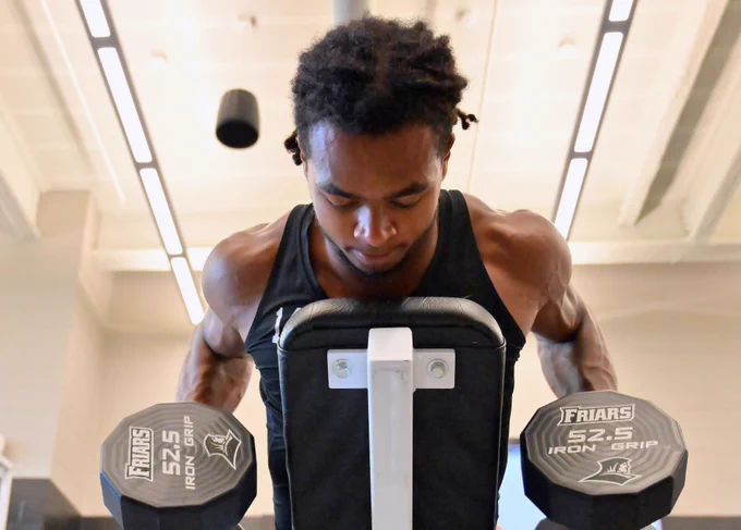 Corey Floyd Jr. lifting dumbbells in the weight room