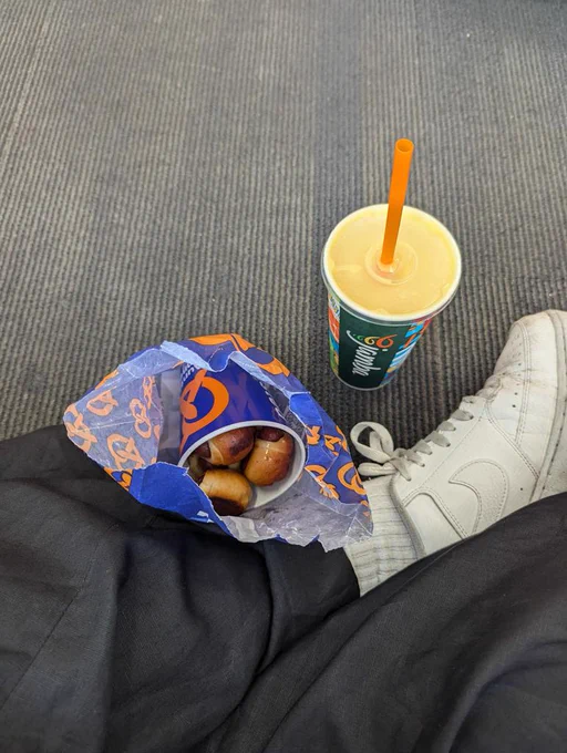 a bag of Aunt Anne's pretzel dogs and smoothie from Jamba Juice on a carpeted floor