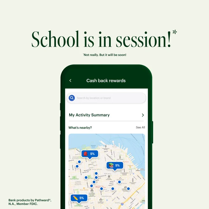 On a tan background, a smartphone displays a screen with a map image that hosts a variety of green pins, highlighting the locations of retailers offering 5% cash back. Above, the dark green headline reads: School is in session!* *Not really, but it will be soon! Bank products provided by Pathward®, N.A., Member FDIC.