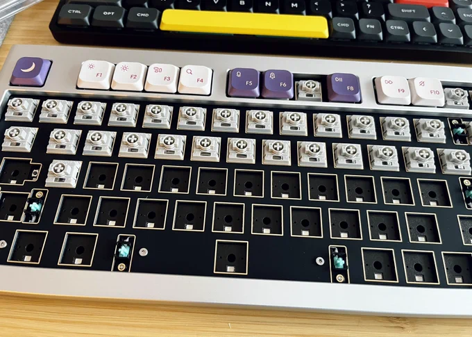 Keyboard partly assembled with some switches and some keycaps attached.