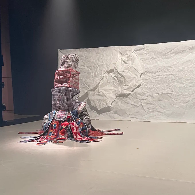 On a white stage, a pile of patterned bag tarps