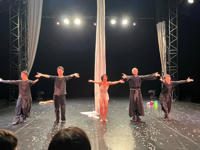 on a circus stage, 5 performer doing curtain call.