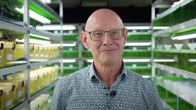 Image of Prof. Joachim Wittbrodt standing in front of fish racks