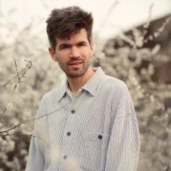 A wistful looking man in a grey shirt