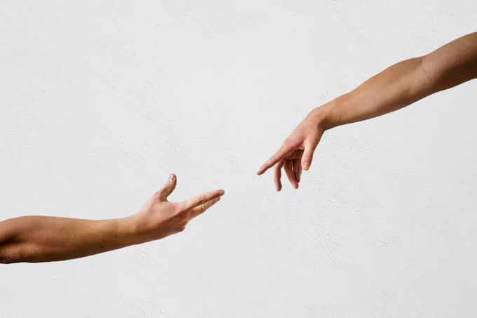 Imagen de dos manos aproximándose. Transmite la idea de conexión entre personas.