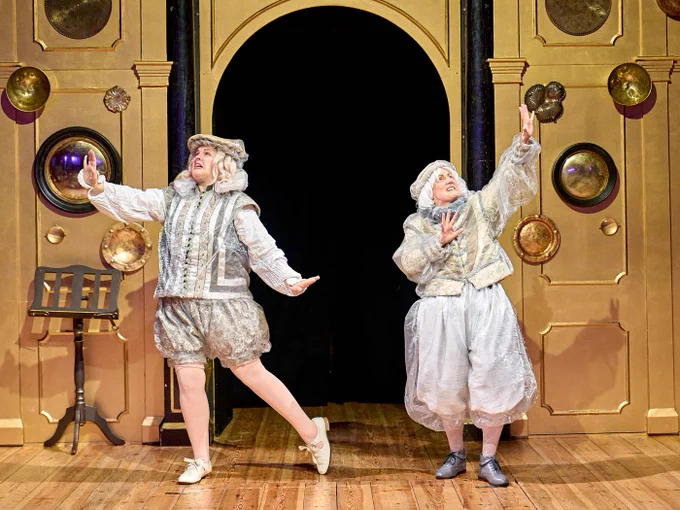 Kerry Frampton as Ghost Guardian and Bryony Twydle as Ghost Guardian in Rough Magic (2024) - onstage in the Sam Wanamaker Playhouse in white traditional clothing, posing and looking distressed and upset.