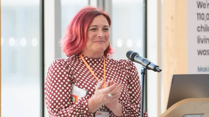 A photo of Catherine smiling and applauding at a presentation ceremony. 