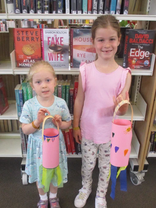 two girls holding crafted windsocks