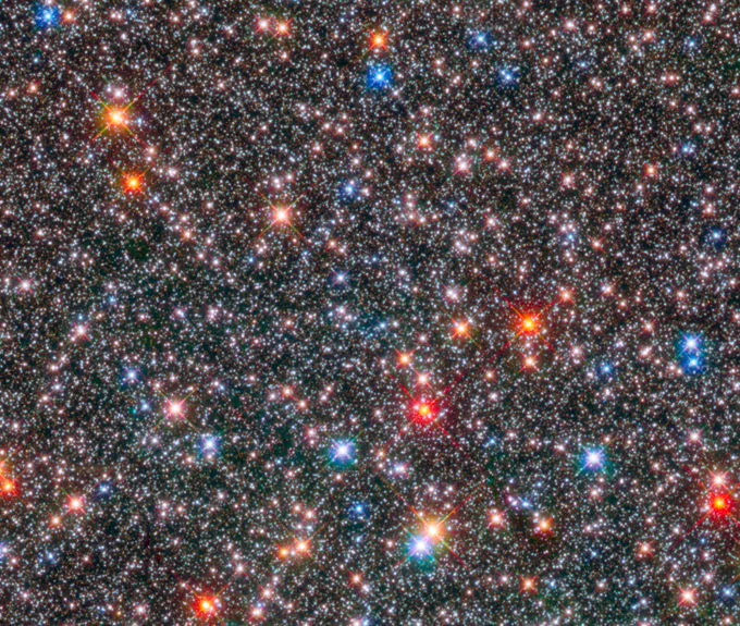 Milky Way Bulge. Several stars fill the image, ranging in hues of white, red, blue, and orange.