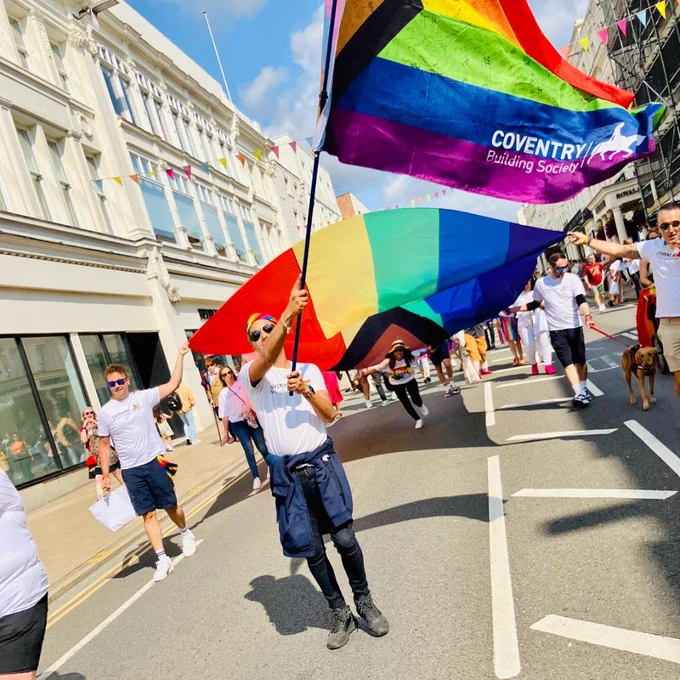 Colleague holding the Societies Pride flag in the Warwickshire Pride parade. 