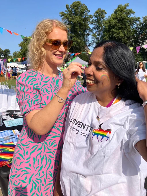 Two colleagues face painting at Warwickshire Pride 2024. 