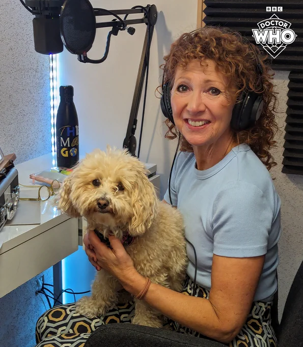 Bonnie Langford in a recording studio, with her dog sitting on her lap.
