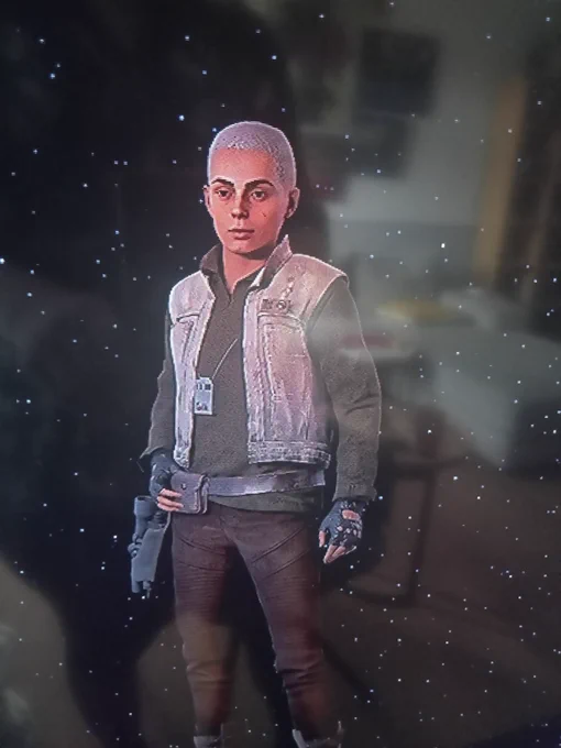 A human with a white buzz cut and cool denim-y vest