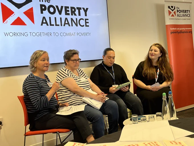 A panel of people sitting and speaking to the audience
