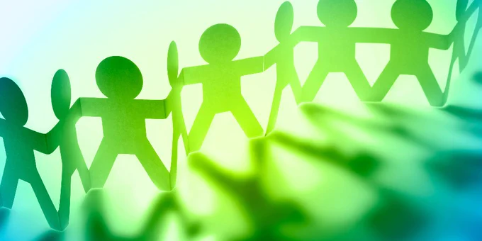 Paper cutouts of people joining hands in a line, symbolising solidarity and collaboration
