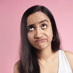 A fed-up looking girl on a pink background