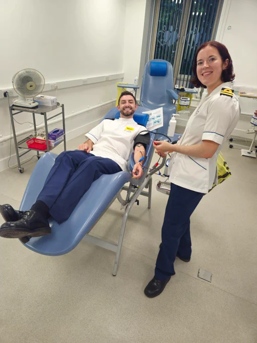A defence apheresis nurse donates blood while another collects it