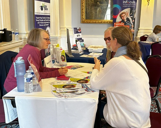 Clients attending the Living Well with Sight Loss Exhibition. Talking to Hayley Buscombe from Devon Carers.
