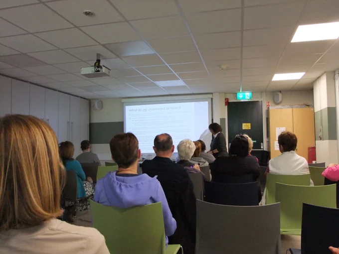 People in a classroom watching a lecturer speak.