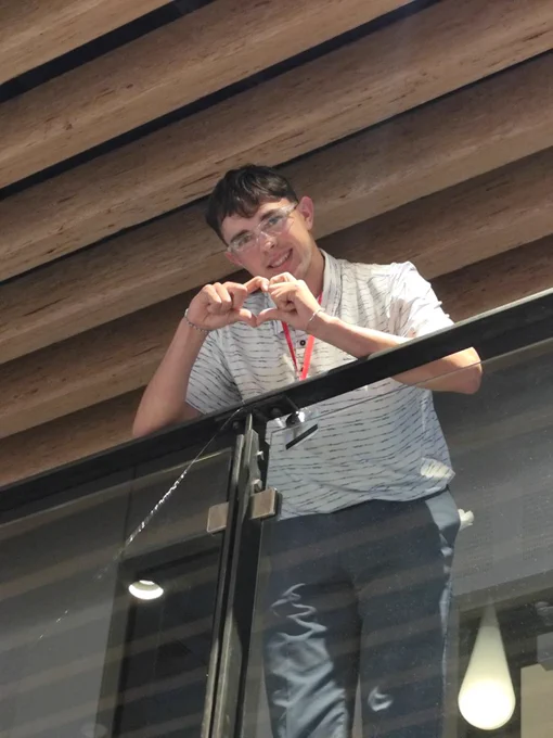 Red Team Ship Facilitator, James, throwing up heart symbol with hands from the balcony above. 