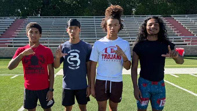 The four Lincoln High School football captains pose for a photo in the middle of the football field
