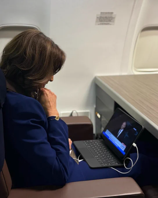 Vice President Kamala Harris watches from a plane on a computer as her husband, Second Gentleman Doug Emhoff, give his speech at the 2024 Democratic National Convention.