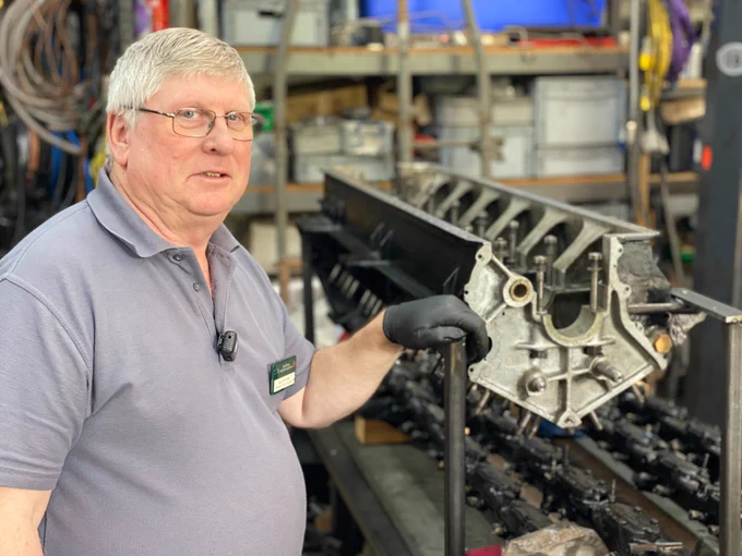 Senior Engineer Ian Stanfield with rear engine crankcase in workshop © Scarf and Goggles