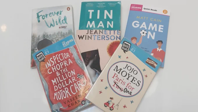 Seven books scattered on a white table top.
All the books are short - less than 200 pages.
Titles include:
Forever Wild; Tin Man; Game On!; Paris for One.