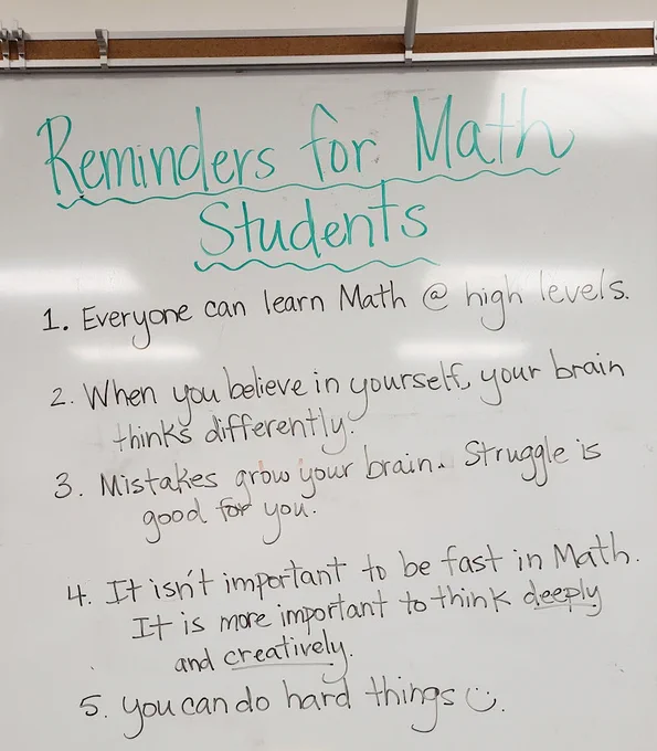 Whiteboard message reads "Reminders for Math Students: 1. Everyone can learn math @ high levels. 2. When you believe in yourself your brain thinks differently. 3. Mistakes grow your brain. Struggle is good for you. 4. It isn't important to be fast in math. It is more important to think deeply and creatively. 5. You can do hard things."
