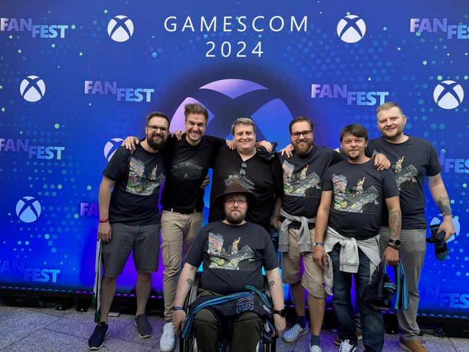 A photo taken in front of the Xbox FanFest photo wall, showing Loki and Leator between the group they falsely named „Red Shirts“, awesome people we meet every year during gamescom