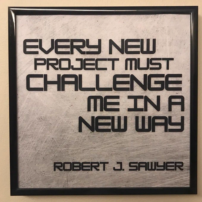 Framed photo features a quote from Robert J. Sawyer. Text reads: "Every new project must challenge me in some new way."