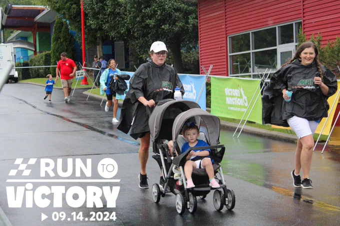 Participants running on Victory Circle during Run to Victory. The Run to Victory logo is in the bottom left corner.